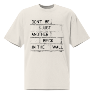 Oversized statement t-shirt in zandkleur met bakstenen muur print en tekst "Don't Be Just Another Brick In The Wall" op de borst.