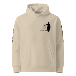 Voorkant van zandkleurige unisex hoodie met marionettenspeler 'Manipulation' print op de borst en 'Be ungovernable' tekst op beide mouwen — anti-systeem statement hoodie van biologisch katoen.